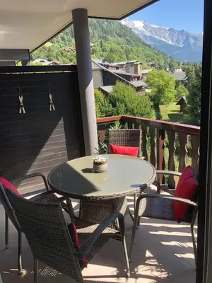 a table and chairs on a balcony with a view at Taragan - Totally Refurbished 3 bed apt, Central St Gervais! in Saint-Gervais-les-Bains