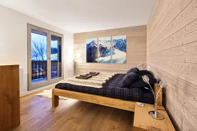 a bedroom with a bed and two windows at Taragan - Totally Refurbished 3 bed apt, Central St Gervais! in Saint-Gervais-les-Bains