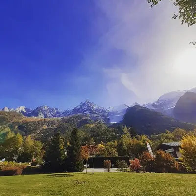a view of a mountain range with trees and a house at Appartement Chamonix Bossons in Chamonix-Mont-Blanc