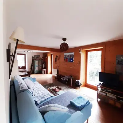 a living room with a blue couch and a television at Appartement Chamonix Bossons in Chamonix-Mont-Blanc