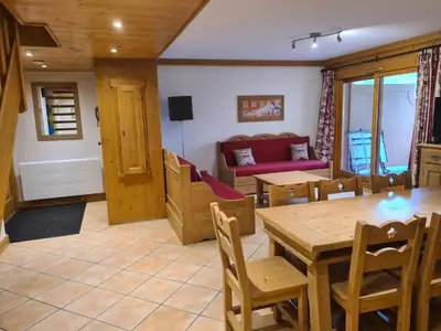 a living room with a table and chairs and a couch at Appartement Le D12 Samoëns in Samoëns