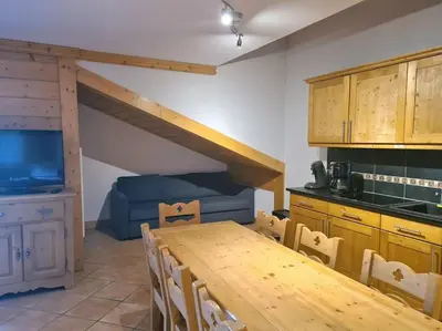 a kitchen and dining room with a table and a couch at Appartement Le D12 Samoëns in Samoëns