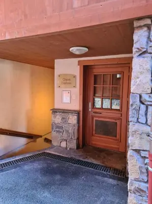 a entrance to a building with a wooden door at Appartement Le D12 Samoëns in Samoëns
