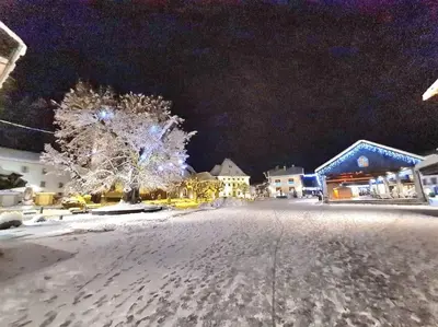 a snow covered street in a town at night at Appartement Le D12 Samoëns in Samoëns