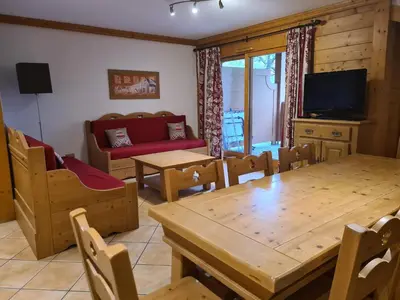 a living room with a wooden table and chairs at Appartement Le D12 Samoëns in Samoëns