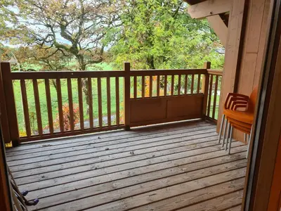 a wooden deck with a chair on it at Appartement Le D12 Samoëns in Samoëns
