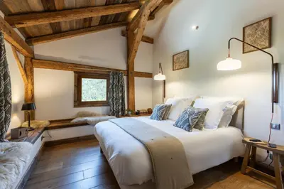 a bedroom with a large white bed and wooden ceilings at Wanderful Life MontBlanc refuge haut de gamme in Saint-Gervais-les-Bains