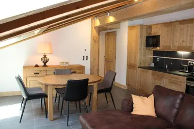 a kitchen and dining room with a table and chairs at RESIDENCE SASKYA in Samoëns