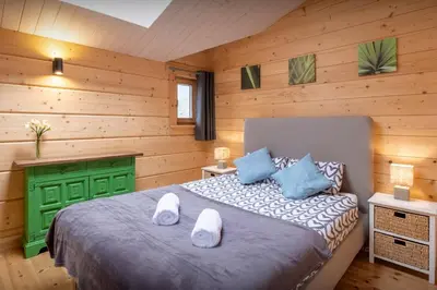 a bedroom with a bed in a wooden room at Chalet Choquette - OVO Network in Les Houches