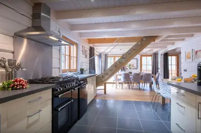 a kitchen with a staircase leading to a dining room at Chalet Choquette - OVO Network in Les Houches