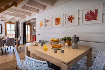 a dining room with a wooden table and chairs at Chalet Choquette - OVO Network in Les Houches