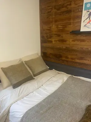 a bed in a room with a wooden wall at Le LihamWood in Megève