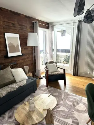a living room with a couch and a table at Le LihamWood in Megève