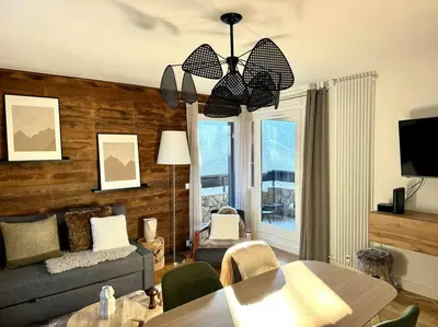 a living room with a couch and a dining table at Le LihamWood in Megève