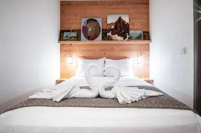 a bed with two towels in the shape of swans at Le Savoy - Terrasse avec vue sur le Mont-Blanc in Chamonix-Mont-Blanc
