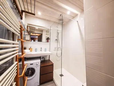 a bathroom with a shower and a washing machine at Le Savoy - Terrasse avec vue sur le Mont-Blanc in Chamonix-Mont-Blanc