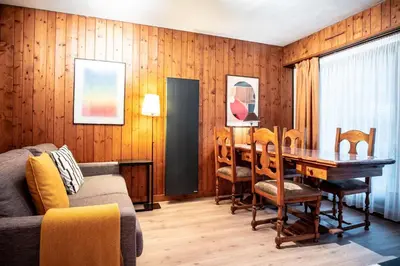 a living room with a table and chairs and a couch at Le Savoy - Terrasse avec vue sur le Mont-Blanc in Chamonix-Mont-Blanc