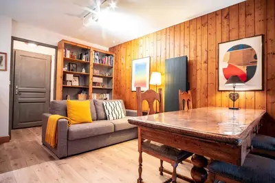 a living room with a couch and a table at Le Savoy - Terrasse avec vue sur le Mont-Blanc in Chamonix-Mont-Blanc