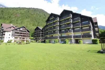 a large building with a grass field in front of it at Le Savoy - Terrasse avec vue sur le Mont-Blanc in Chamonix-Mont-Blanc