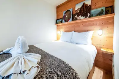 a bedroom with a bed with white towels on it at Le Savoy - Terrasse avec vue sur le Mont-Blanc in Chamonix-Mont-Blanc