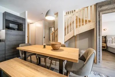 a dining room with a wooden table and chairs at Kotibé Chamonix - BY EMERALD STAY in Chamonix-Mont-Blanc