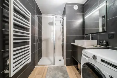 a bathroom with a shower and a washing machine at Kotibé Chamonix - BY EMERALD STAY in Chamonix-Mont-Blanc