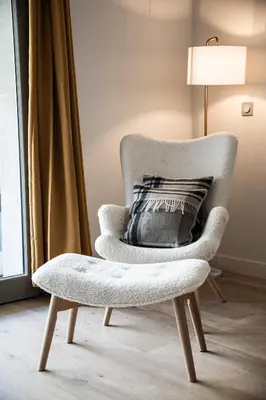 a chair with a pillow on it next to a window at Kabano Chamonix - BY EMERALD STAY in Chamonix-Mont-Blanc