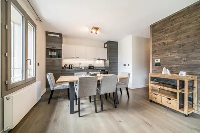 a kitchen and dining room with a wooden table and chairs at Kalmia Chamonix - BY EMERALD STAY in Chamonix-Mont-Blanc