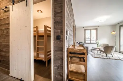 a room with a wooden wall and a room with a bunk bed at Kalmia Chamonix - BY EMERALD STAY in Chamonix-Mont-Blanc