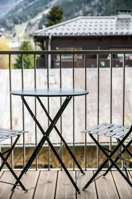 a table and two chairs on a deck at Kalmia Chamonix - BY EMERALD STAY in Chamonix-Mont-Blanc
