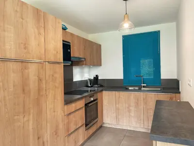 a kitchen with wooden cabinets and a blue blind at Appartement familial à Samoëns, animaux admis, Wi-Fi inclus - FR-1-624-133 in Samoëns