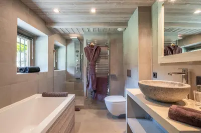 a bathroom with a tub and a toilet and a sink at Chalet Mozart I Le Chalet Club in Megève