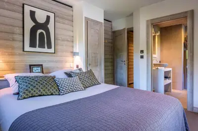 a bedroom with a large bed with pillows at Chalet Mozart I Le Chalet Club in Megève