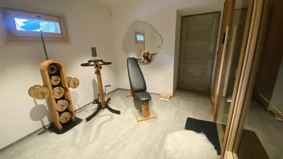 a room with a mirror and a chair and a treadmill at Chalet Mozart I Le Chalet Club in Megève