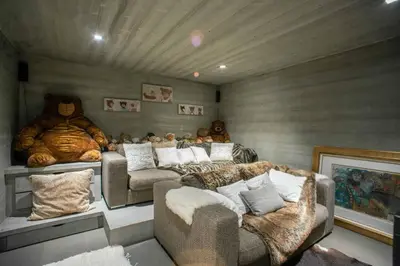 a living room with couches and a teddy bear wall at Chalet Mozart I Le Chalet Club in Megève