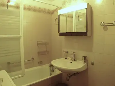 a bathroom with a sink and a tub and a mirror at 2 pièces confortable & lumineux au centre de Samoëns - Animaux admis et parking inclus - FR-1-629-126 in Samoëns
