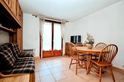 a dining room with a table and chairs and a couch at Résidence Les Sapins - Les Sapins 2 MAE-0514 in Les Houches