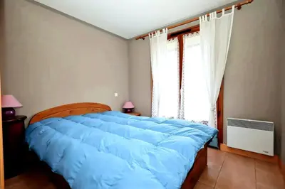 a bedroom with a large blue bed with a window at Résidence Les Sapins - Les Sapins 2 MAE-0514 in Les Houches