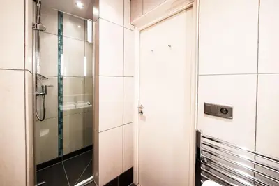 a bathroom with a toilet and a glass shower at Les Aiguilles du Brevent - Grand Appt Renove - Central - Terrasse avec Vue in Chamonix-Mont-Blanc