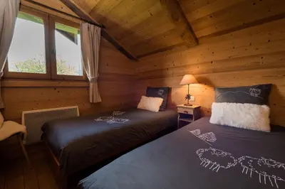 a bedroom with two beds in a log cabin at Le Mazot de Janton in Combloux