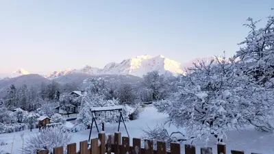a snow covered mountain with a fence and trees at Le Mazot de Janton in Combloux