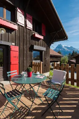 a patio with a table and two chairs and a barn at Le Mazot de Janton in Combloux