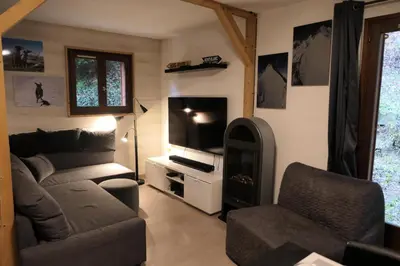 a living room with a couch and a tv at Les Chalet Du Soleil - Chalets du Soleil 9 MAE-6344 in Saint-Gervais-les-Bains