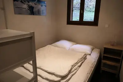 a small bed in a room with a window at Les Chalet Du Soleil - Chalets du Soleil 9 MAE-6344 in Saint-Gervais-les-Bains