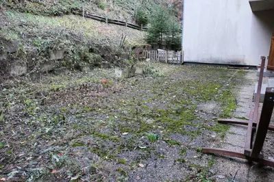 a yard with leaves on the ground next to a building at Les Chalet Du Soleil - Chalets du Soleil 9 MAE-6344 in Saint-Gervais-les-Bains