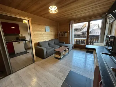a living room with a couch and a kitchen at Studio équipé / centre station in Les Carroz d'Araches