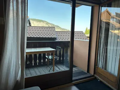 a balcony with a table and a view of a mountain at Studio équipé / centre station in Les Carroz d'Araches