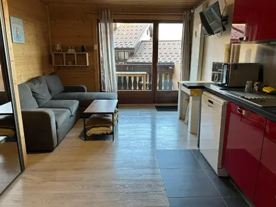 a kitchen and living room with a couch and a table at Studio équipé / centre station in Les Carroz d'Araches