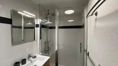 a bathroom with a glass shower and a sink at Cosy Criou - Appartement avec vue sur la montagne in Samoëns