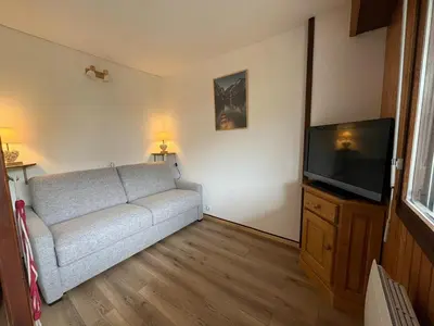 a living room with a couch and a flat screen tv at Cosy Criou - Appartement avec vue sur la montagne in Samoëns